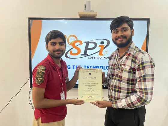 A trainer handing a certificate to a student in front of the SSS India screen